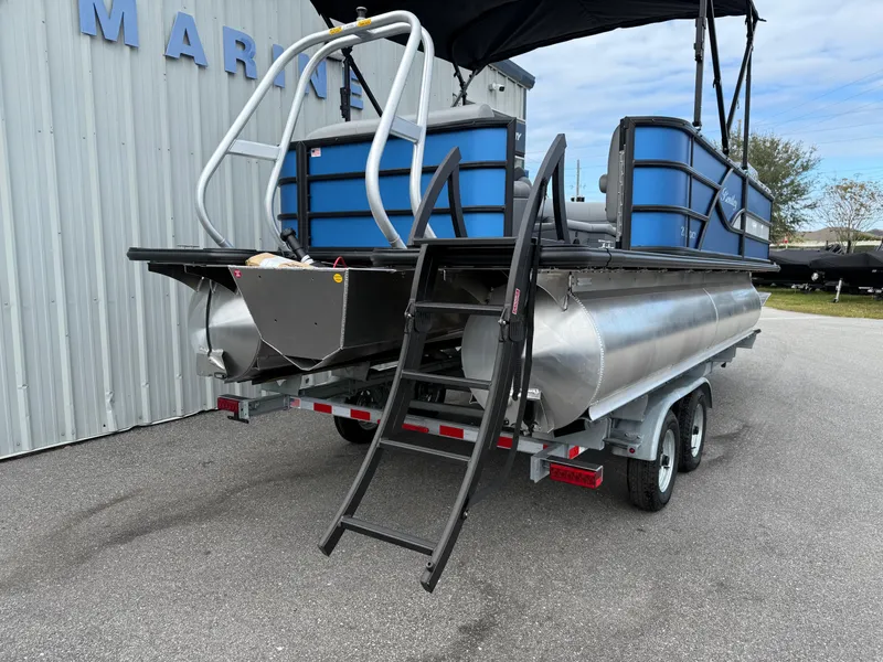 Slide: The Image of 2025 Bentley Pontoons 20 Legacy boat on trailer, rear view with ladder and blue accents. - 16