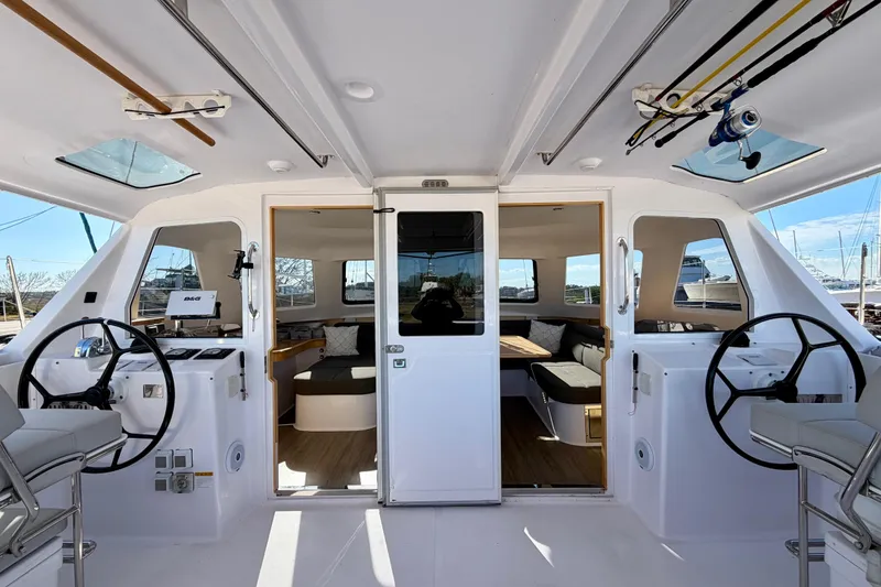 Slide: The Image of 2020 Seawind 1260 catamaran interior with dual steering wheels and spacious seating area. - 105