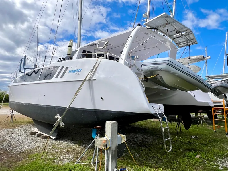 Slide: The Image of 2020 Seawind 1260 catamaran on land, surrounded by other boats, under a blue sky. - 6