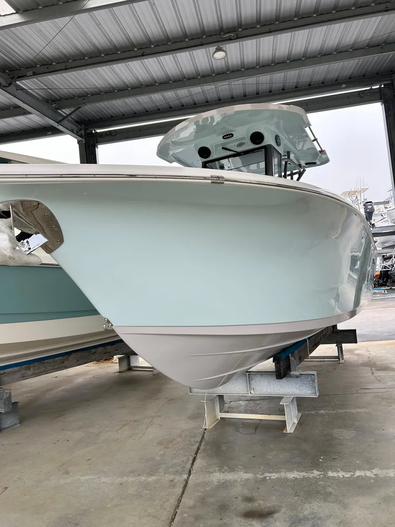 Slide: The Image of 2025 Sea Pro 262 Offshore boat under a covered dock, side view. - 0