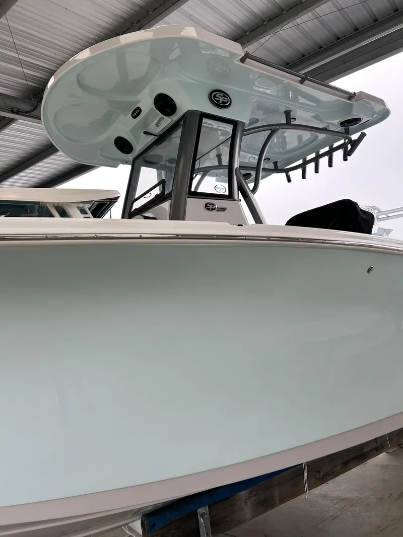 Slide: The Image of 2025 Sea Pro 262 Offshore boat under a metal roof, showcasing sleek design and modern features. - 2