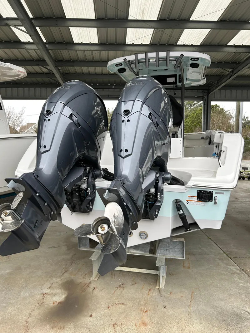 Slide: The Image of 2025 Sea Pro 262 Offshore boat with dual outboard engines in a covered storage area. - 3