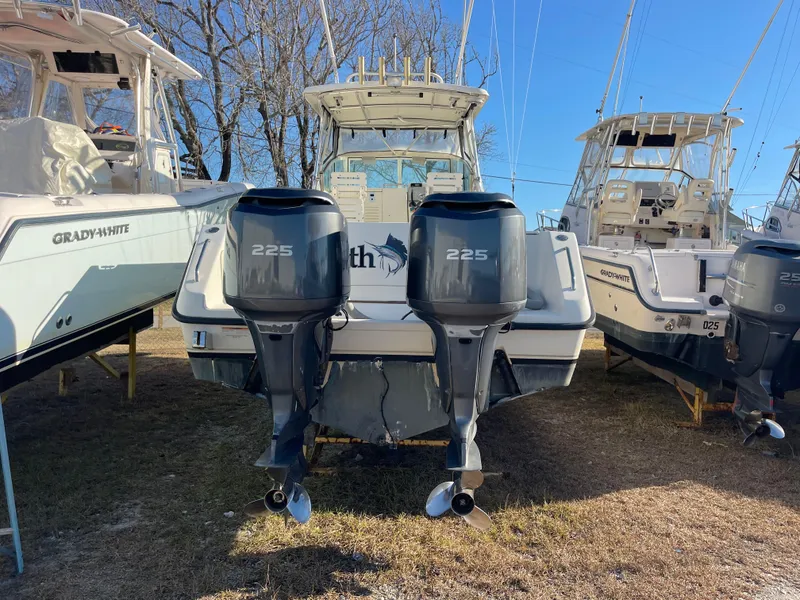 Slide: The Image of 2003 Pursuit 2870 Walkaround boat with twin 225 horsepower engines, docked outdoors. - 10