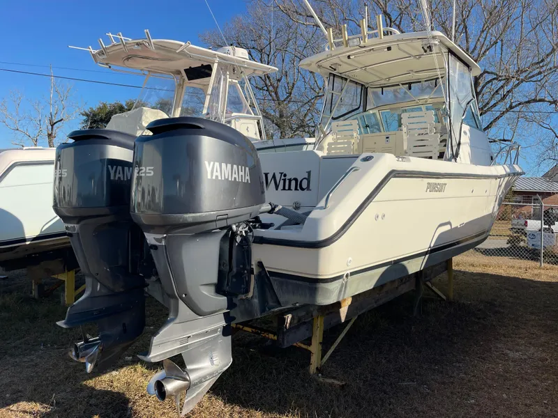 Slide: The Image of 2003 Pursuit 2870 Walkaround boat with twin Yamaha engines, parked on grass. - 12