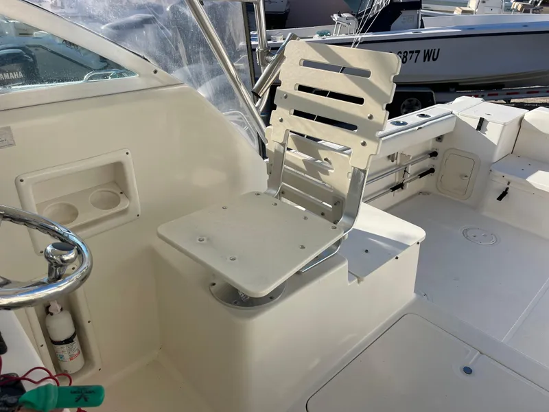 Slide: The Image of 2003 Pursuit 2870 Walkaround boat interior with helm seat and steering wheel. - 25