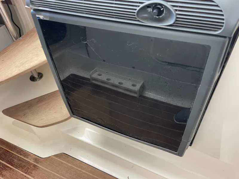 Slide: The Image of 2003 Pursuit 2870 Walkaround cabin interior with wooden steps and storage compartment. - 28