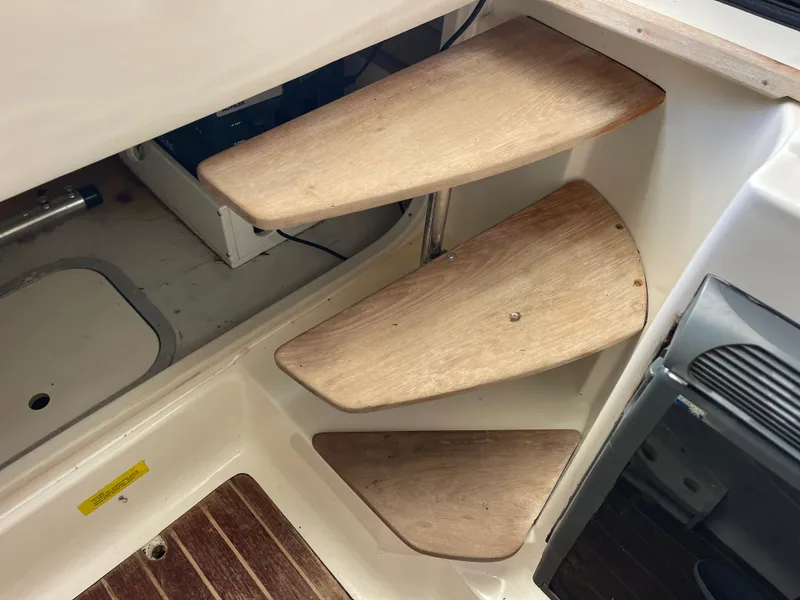 Slide: The Image of Wooden steps inside a 2003 Pursuit 2870 Walkaround boat, leading to cabin area. - 29