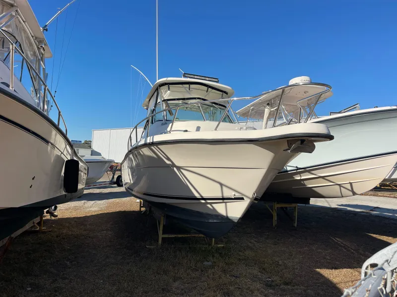 Slide: The Image of 2003 Pursuit 2870 Walkaround boat on display in a marina under clear blue sky. - 3