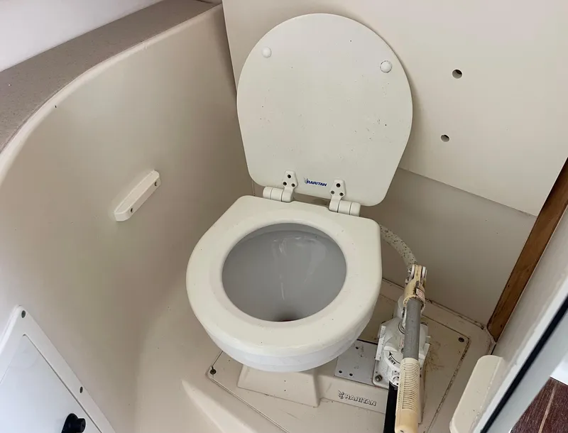 Slide: The Image of 2003 Pursuit 2870 Walkaround boat toilet, compact marine bathroom interior. - 32