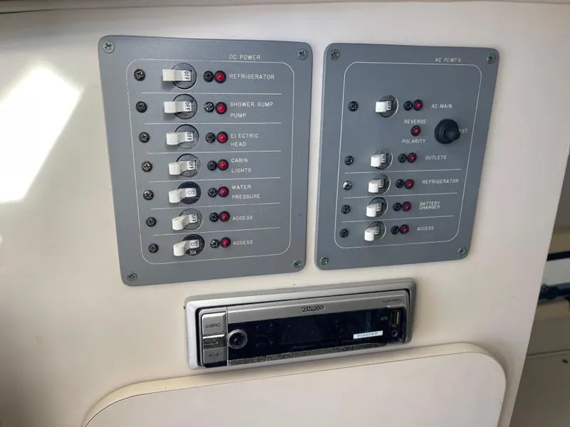 Slide: The Image of Control panel of a 2003 Pursuit 2870 Walkaround boat with switches and stereo system. - 36