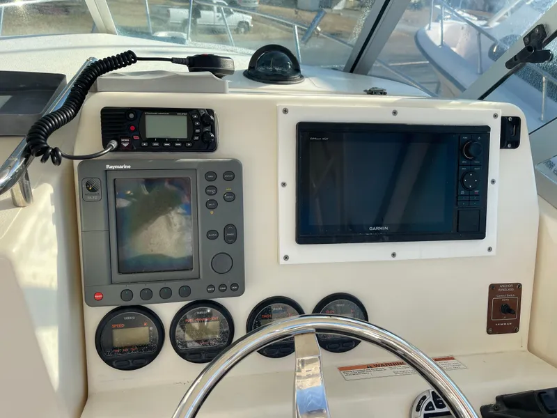 Slide: The Image of 2003 Pursuit 2870 Walkaround boat dashboard with navigation and communication equipment. - 39