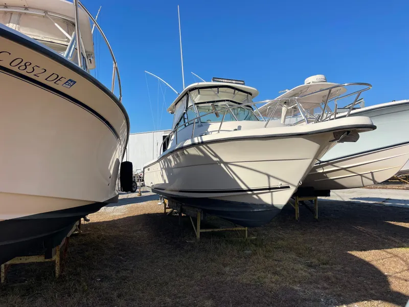 Slide: The Image of 2003 Pursuit 2870 Walkaround boat on display in a marina, surrounded by other vessels. - 4