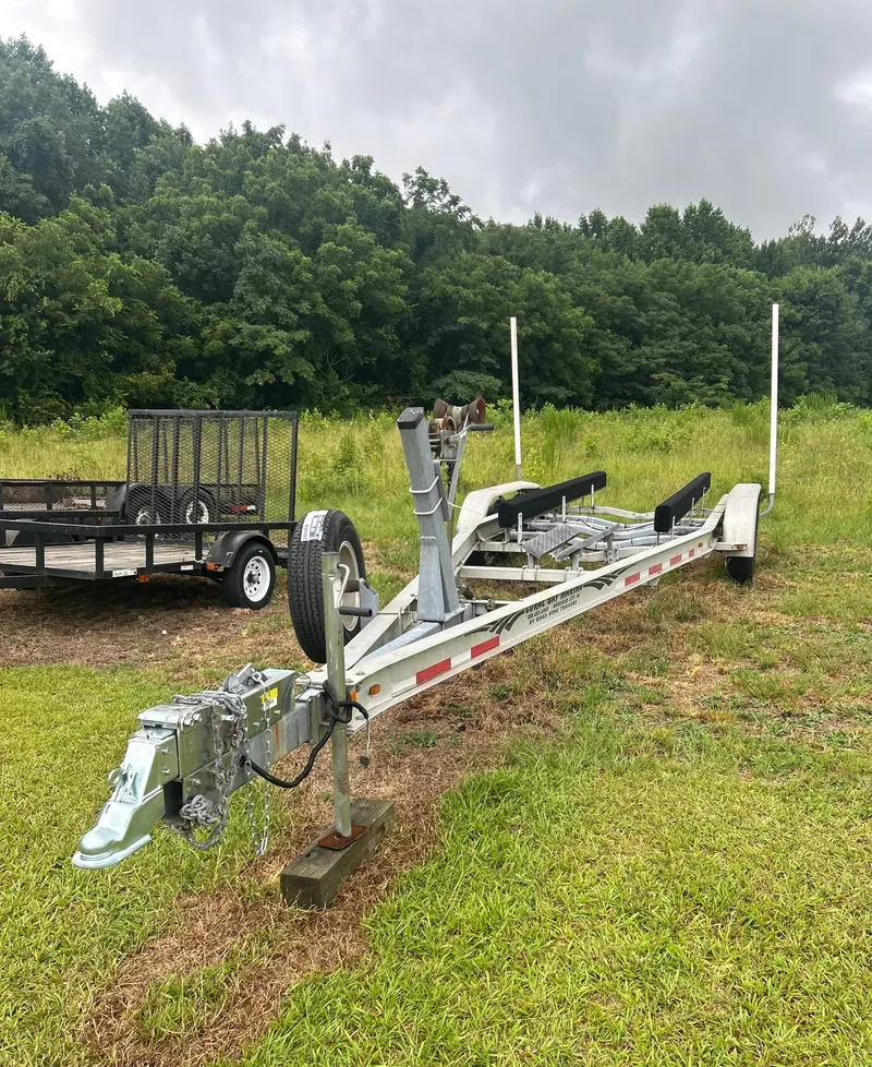 Slide: The Image of Boat trailer for 2003 Pursuit 2870 Walkaround, parked on grassy field with forest background. - 42