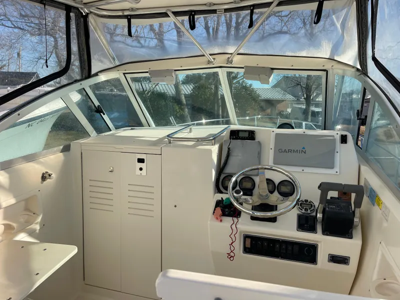 Slide: The Image of 2003 Pursuit 2870 Walkaround boat cockpit with Garmin navigation system and steering wheel. - 8