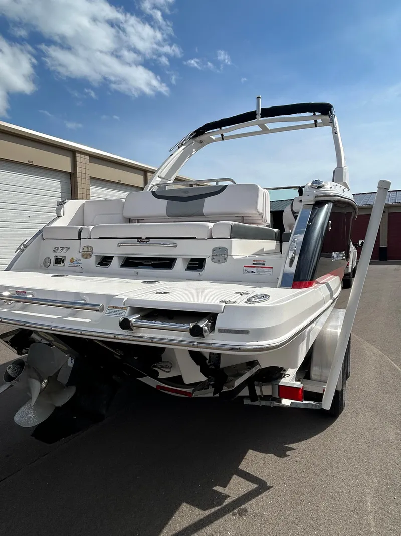Slide: The Image of 2019 Chaparral 277 SSX boat, rear view, parked outdoors under a clear sky. - 12