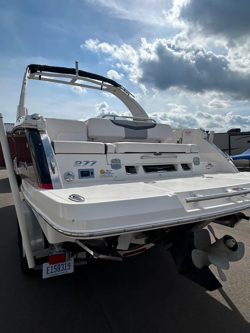 Slide: The Image of 2019 Chaparral 277 SSX boat, rear view, parked under a cloudy sky. - 13