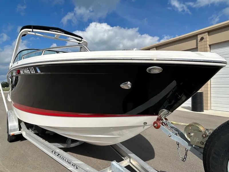 Slide: The Image of 2019 Chaparral 277 SSX boat on trailer, black and white design, clear sky background. - 2