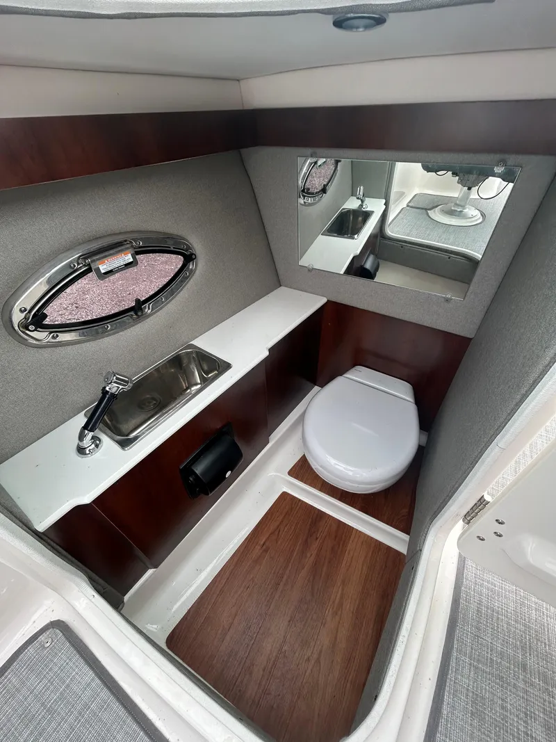 Slide: The Image of 2019 Chaparral 277 SSX boat interior bathroom with sink, toilet, and mirror. - 25