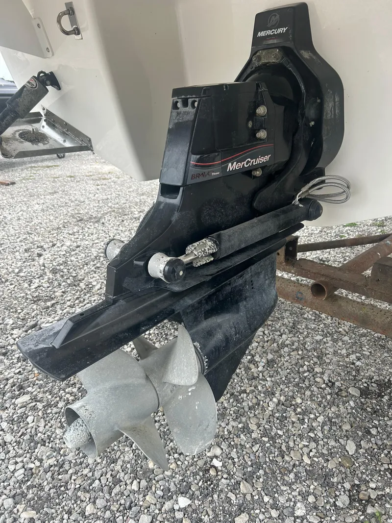 Slide: The Image of MerCruiser outdrive on 2019 Chaparral 277 SSX boat, resting on gravel surface. - 34