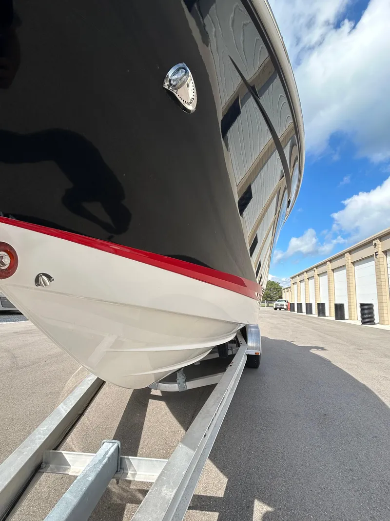 Slide: The Image of 2019 Chaparral 277 SSX boat on trailer, black hull, red stripe, outdoor storage. - 5