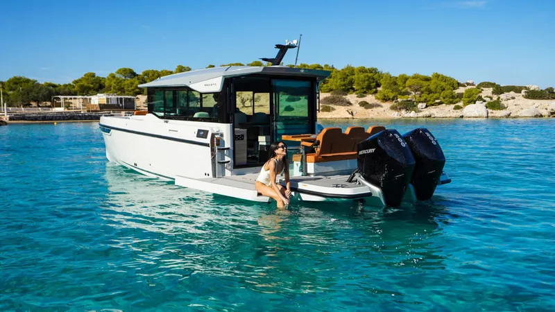 Slide: The Image of 2025 Saxdor 320 GTC boat on clear water with a person enjoying the view. - 15