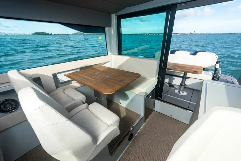 Slide: The Image of Interior of 2025 Saxdor 320 GTC boat with seating and wooden tables on the water. - 7
