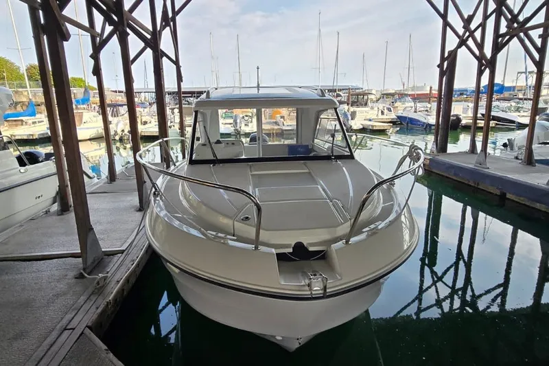 Slide: The Image of 2022 Beneteau Antares 7 docked in a marina, surrounded by other boats. - 6