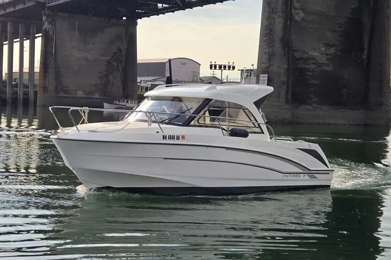 Slide: The Image of 2022 Beneteau Antares 7 boat cruising under a bridge on calm water. - 3