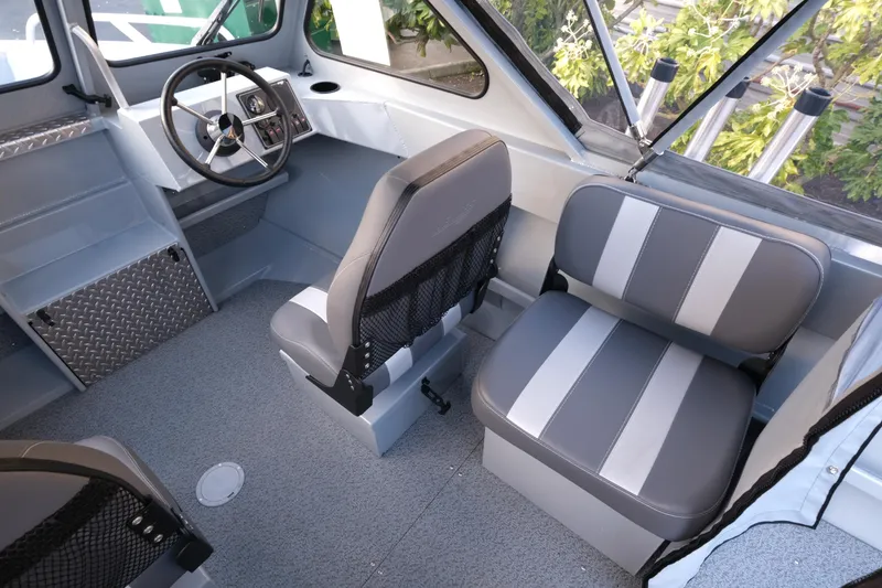 Slide: The Image of Interior of 2025 Hewescraft 180 Sportsman boat with gray seating and steering wheel. - 10