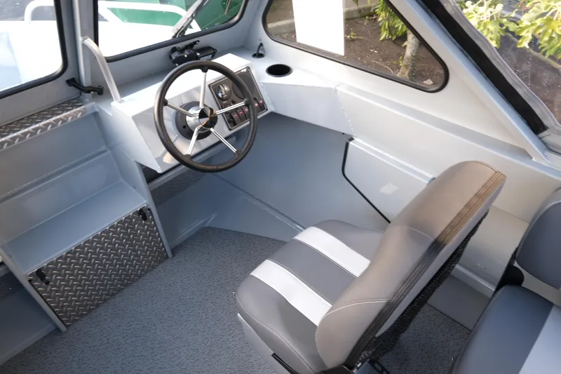Slide: The Image of 2025 Hewescraft 180 Sportsman boat interior with steering wheel and seating. - 11