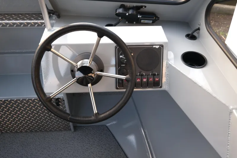 Slide: The Image of 2025 Hewescraft 180 Sportsman boat steering wheel and control panel. - 12