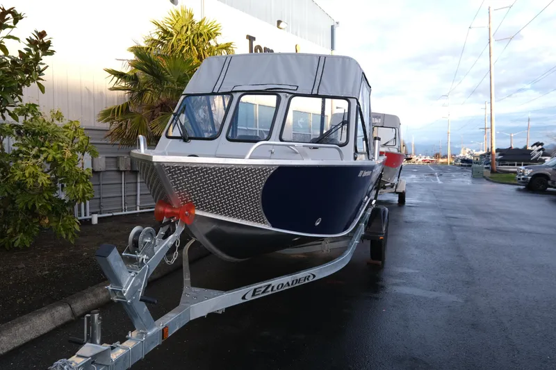 Slide: The Image of 2025 Hewescraft 180 Sportsman boat on trailer, parked outdoors. - 3