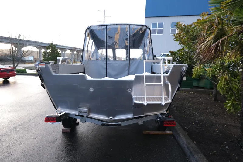 Slide: The Image of 2025 Hewescraft 180 Sportsman boat, rear view, parked outdoors on a wet surface. - 5
