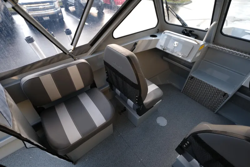Slide: The Image of Interior of 2025 Hewescraft 180 Sportsman boat with gray seating and dashboard. - 9