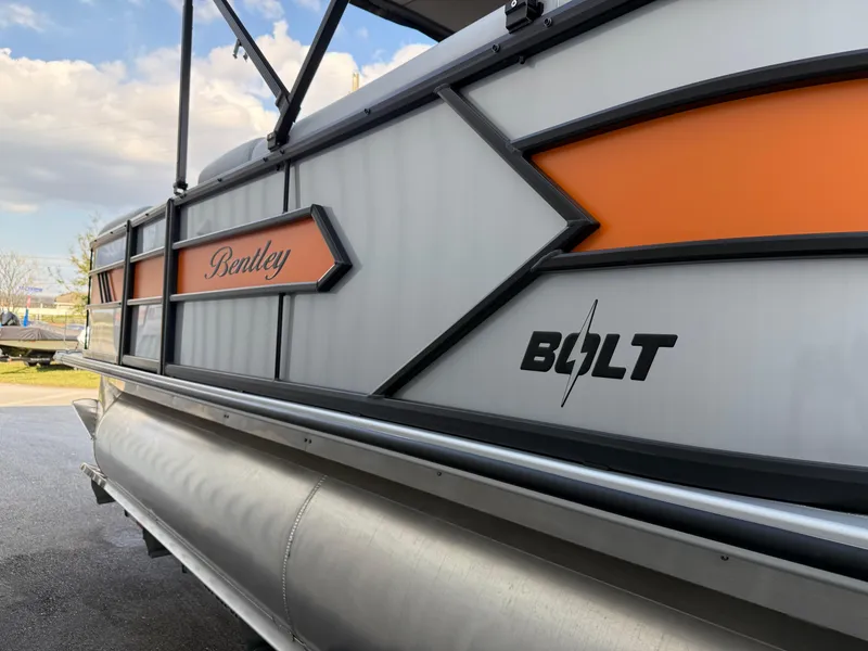 Slide: The Image of 2025 Bentley Pontoons Bolt 203, side view with orange accents and logo. - 15