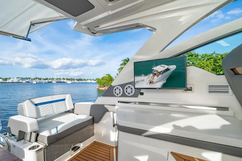 Slide: The Image of 2025 Tiara Yachts 34 LX interior with seating, TV, and scenic water view. - 15