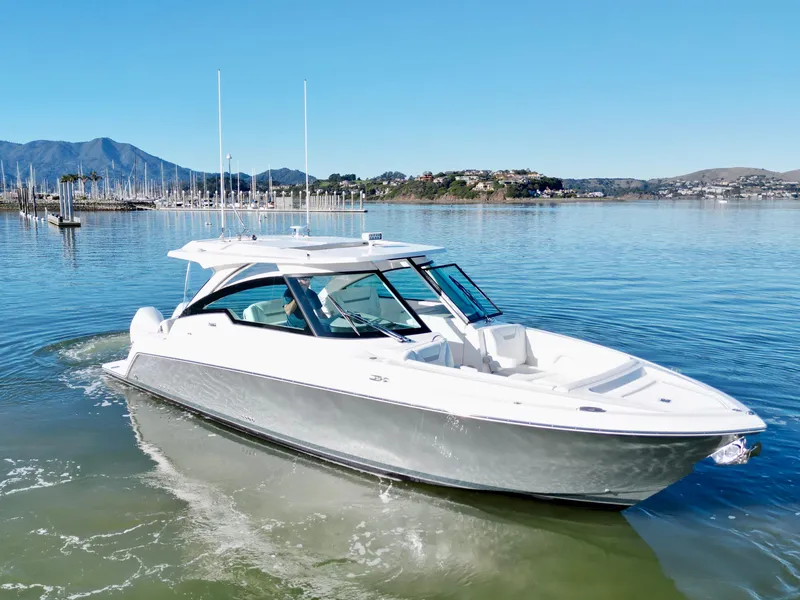 Slide: The Image of 2025 Tiara Yachts 34 LX cruising on calm waters with scenic mountain backdrop. - 22