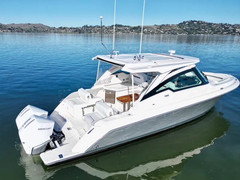 Slide: The Image of 2025 Tiara Yachts 34 LX on calm water, showcasing sleek design and powerful outboard engine. - 3