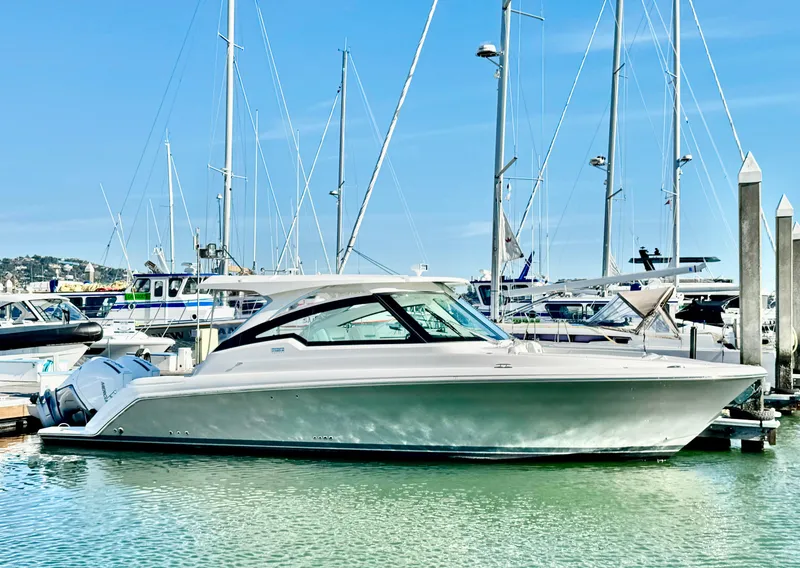 Slide: The Image of 2025 Tiara Yachts 34 LX docked in a marina, surrounded by sailboats. - 33