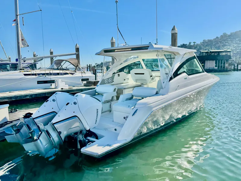 Slide: The Image of 2025 Tiara Yachts 34 LX in marina, showcasing sleek design and powerful outboard engines. - 34