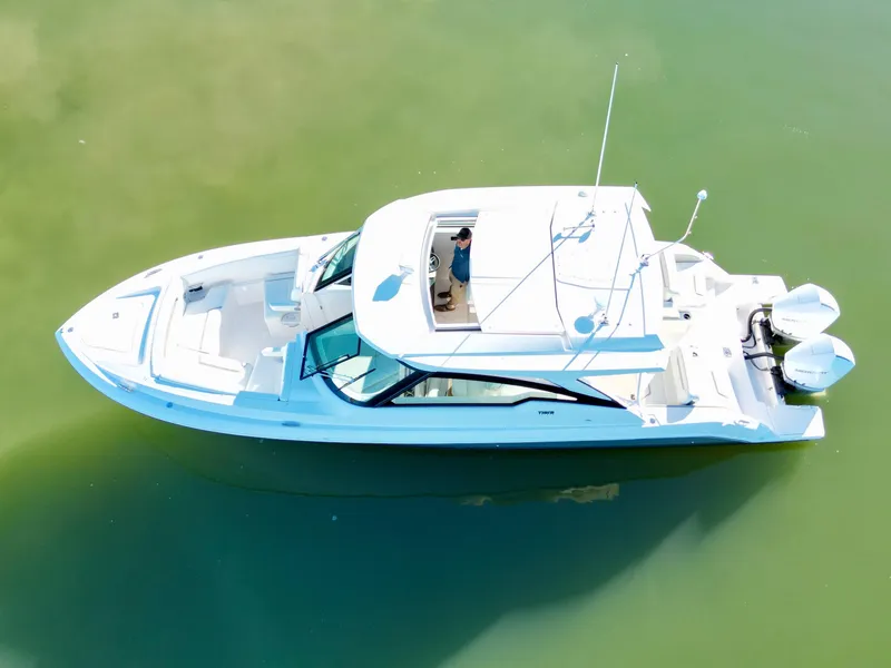 Slide: The Image of 2025 Tiara Yachts 34 LX cruising on calm green waters. - 5