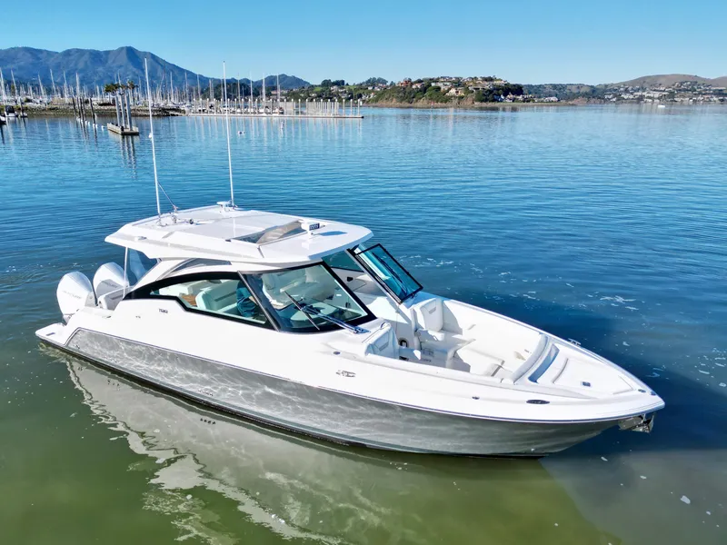 The Image of 2025 Tiara Yachts 34 LX in serene marina setting with distant mountains. - 0