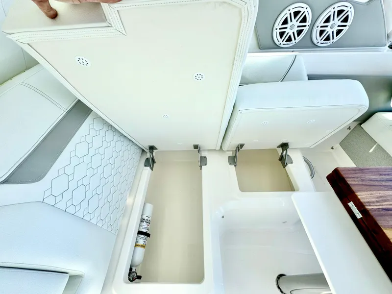 Slide: The Image of 2025 Tiara Yachts 34 LX interior storage compartments with white seating and speakers. - 36