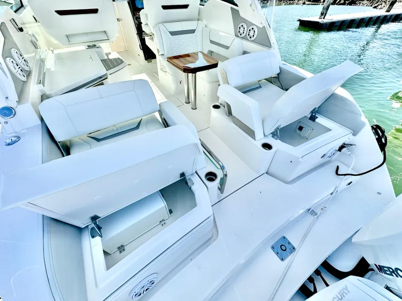 Slide: The Image of 2025 Tiara Yachts 34 LX interior with white seating and storage compartments. - 38