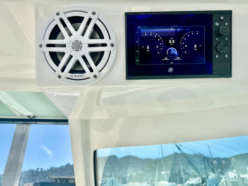 Slide: The Image of 2025 Tiara Yachts 34 LX dashboard with speaker and digital display, marina view. - 47