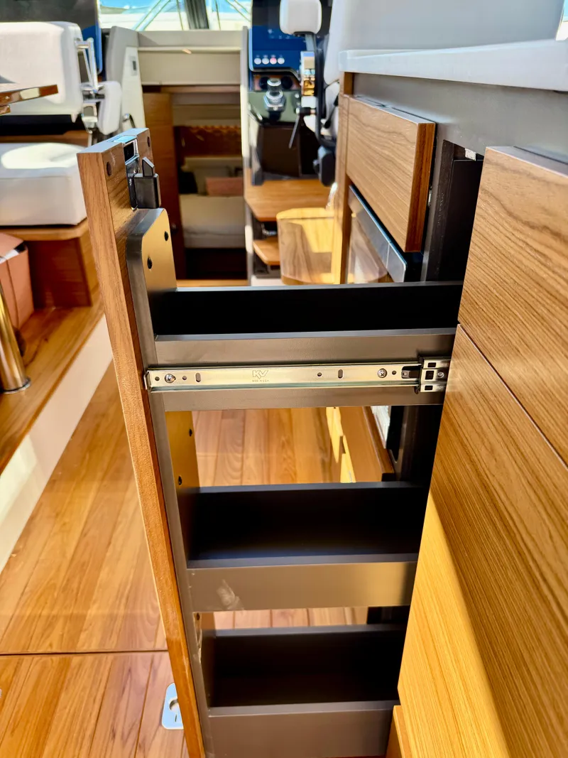 Slide: The Image of 2025 Tiara Yachts 43 LE interior with open wooden storage drawer. - 23