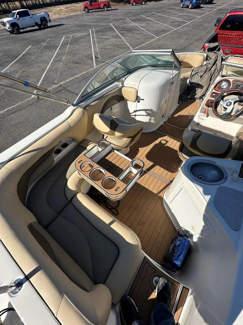 Slide: The Image of 2010 NauticStar 230DC Sport Deck boat interior with seating and steering wheel in parking lot. - 11