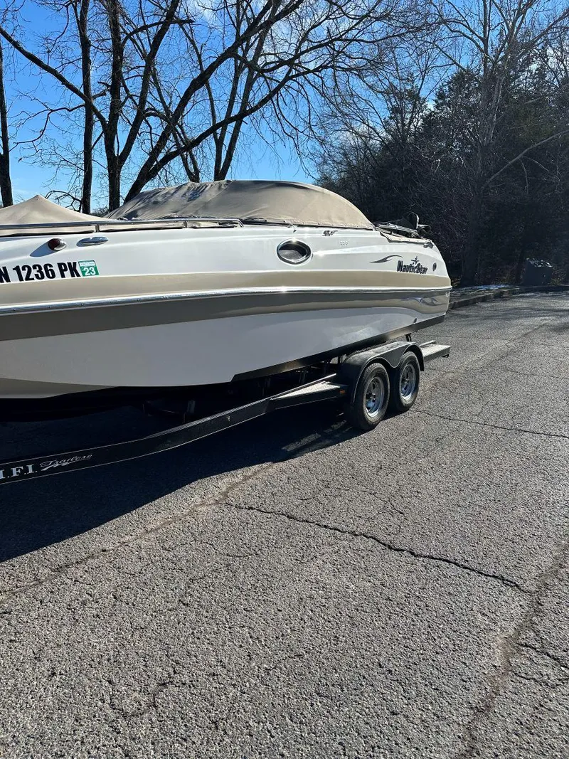 Slide: The Image of 2010 NauticStar 230DC Sport Deck boat on trailer, parked on a sunny day. - 2