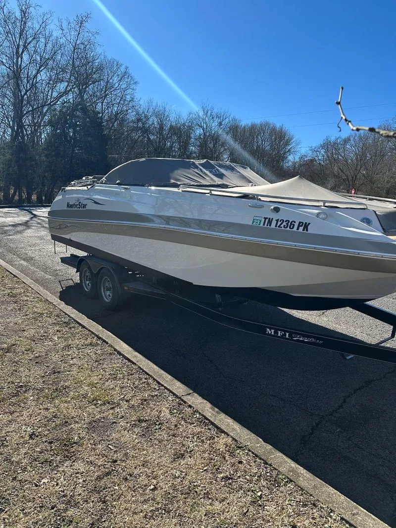 Slide: The Image of 2010 NauticStar 230DC Sport Deck boat on trailer, parked outdoors on a sunny day. - 7