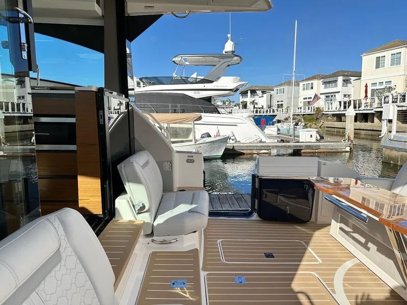 Slide: The Image of 2025 Tiara Yachts 48 LE interior with luxurious seating and marina view. - 10